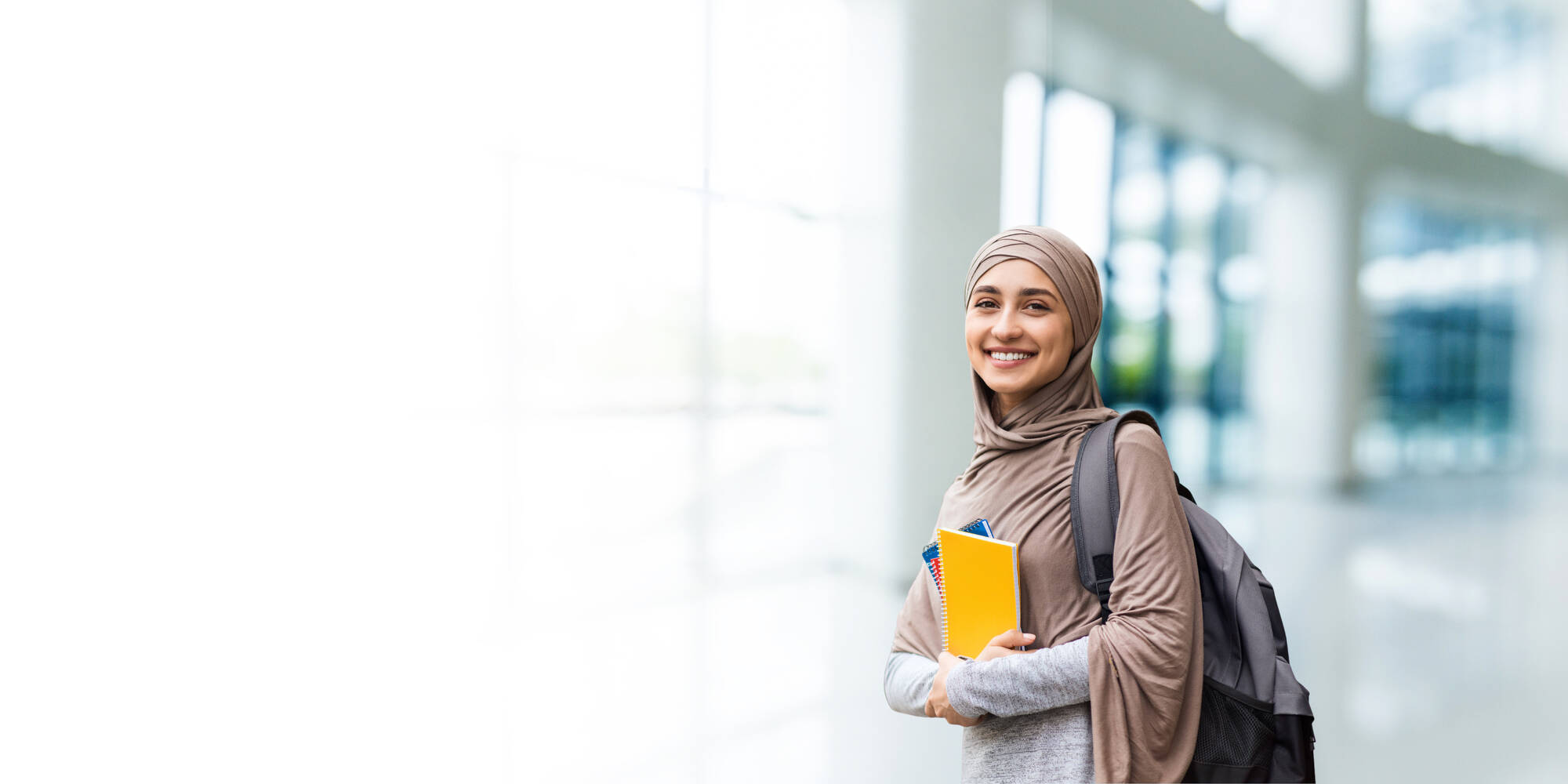 Smiling educator holding texts books